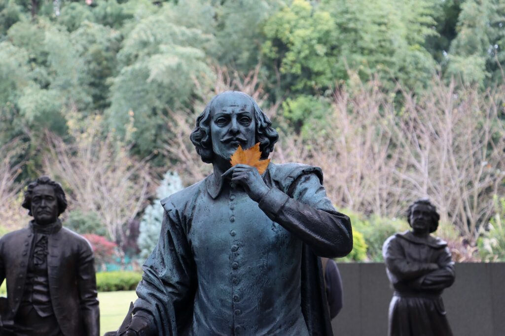 a statue of a Shakespeare holding an orange flower