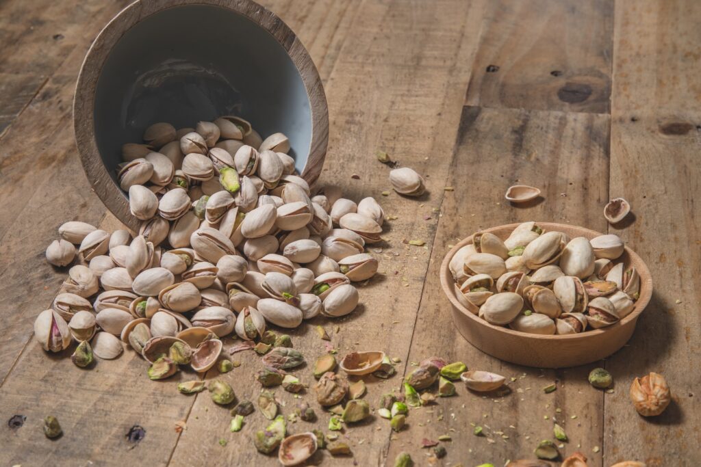 a wooden bowl filled with nuts on top of a wooden table